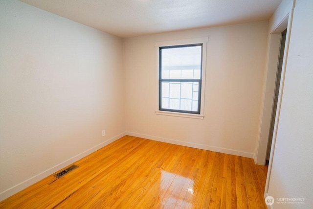 empty room with visible vents, baseboards, and light wood finished floors