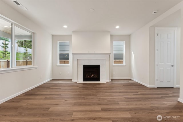 unfurnished living room featuring recessed lighting, baseboards, and wood finished floors