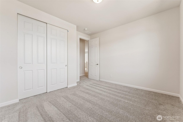 unfurnished bedroom featuring a closet, baseboards, and carpet floors