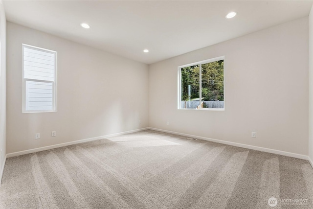 spare room featuring carpet flooring, recessed lighting, and baseboards