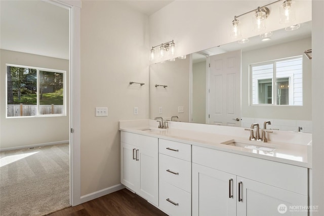 full bath featuring a wealth of natural light, baseboards, and a sink