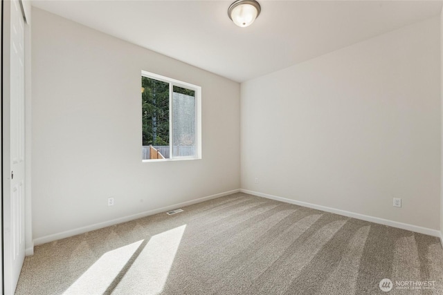 carpeted empty room with visible vents and baseboards