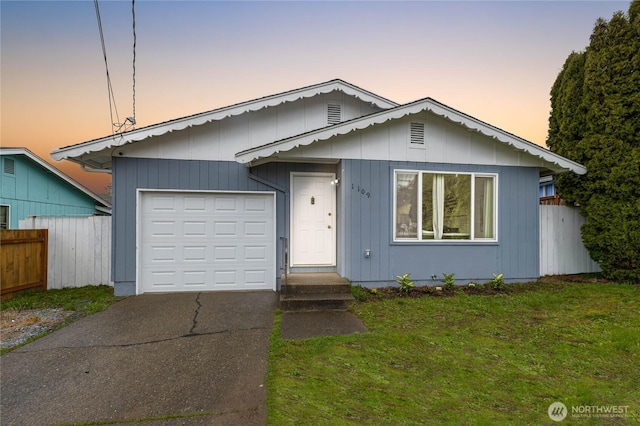 view of front of property featuring an attached garage, concrete driveway, a front yard, and fence