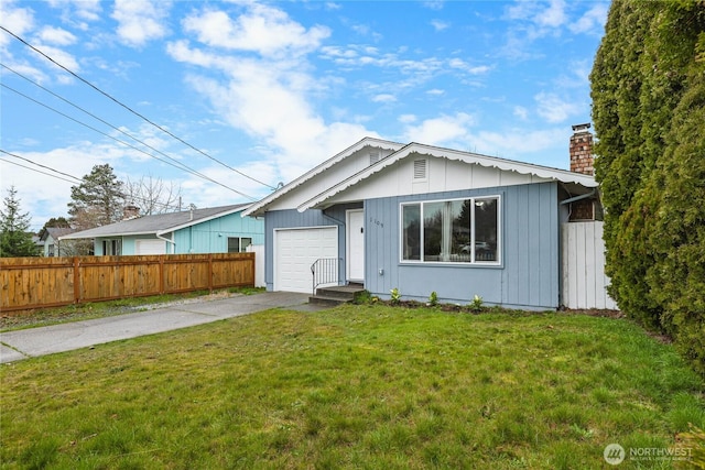 view of front facade with fence, a front yard, a chimney, a garage, and driveway