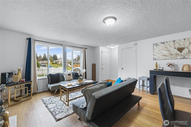 living area featuring light wood finished floors and a textured ceiling