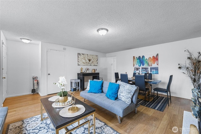 living room featuring light wood-style flooring and a textured ceiling