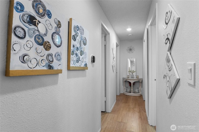 corridor with baseboards and light wood-type flooring