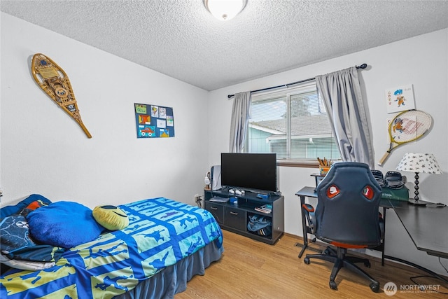 bedroom featuring light wood-style flooring and a textured ceiling