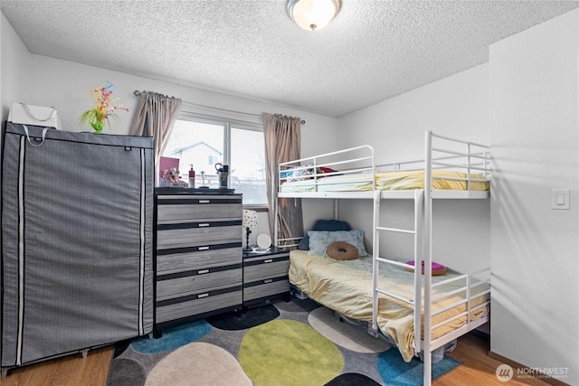 bedroom featuring a textured ceiling and wood finished floors