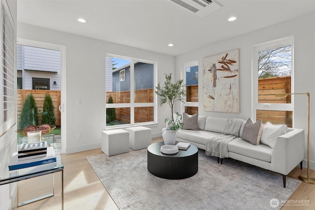 living area with recessed lighting, wood finished floors, and baseboards