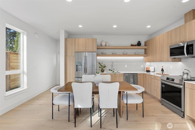 kitchen featuring light brown cabinets, open shelves, appliances with stainless steel finishes, modern cabinets, and tasteful backsplash