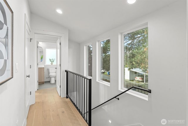 hallway featuring light wood finished floors, recessed lighting, and vaulted ceiling