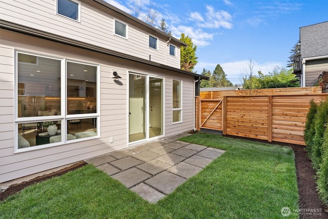 back of house featuring a yard, fence, and a patio area