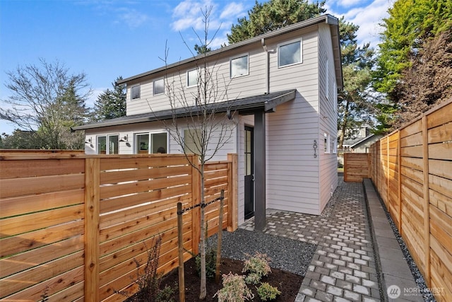 back of property featuring a fenced backyard