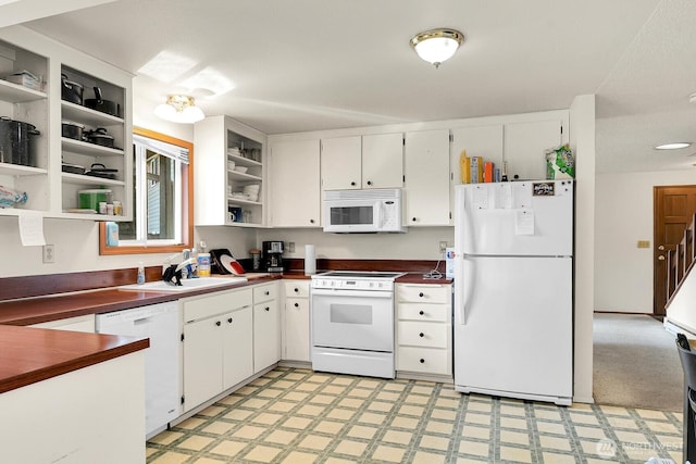 kitchen featuring dark countertops, light floors, white appliances, and open shelves