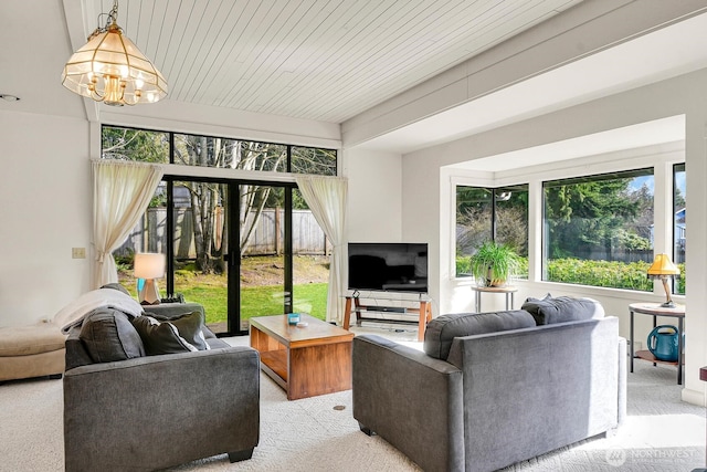 living area with light carpet, plenty of natural light, and a notable chandelier