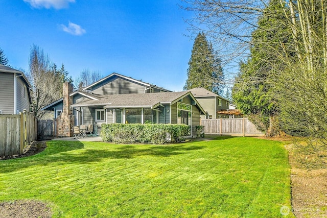 rear view of property with a shingled roof, a lawn, a chimney, a fenced backyard, and a gate