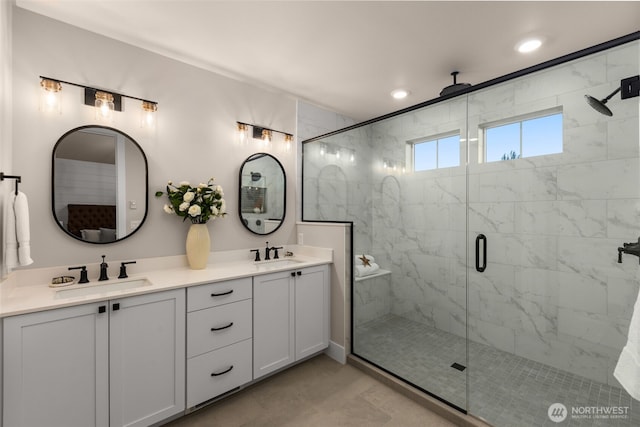 full bath with a sink, double vanity, recessed lighting, and a shower stall