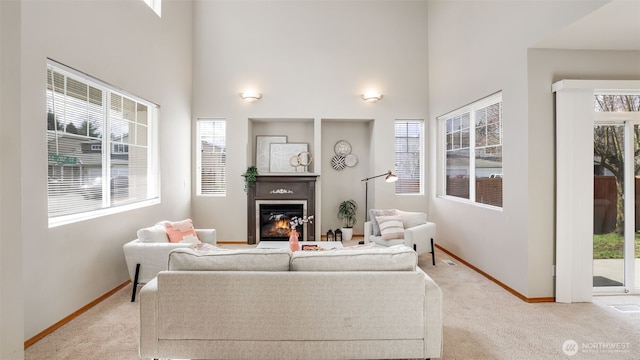 23806 SE 282nd St, Maple Valley, WA 98038 - living area with a glass covered fireplace, light colored carpet, baseboards, and a towering ceiling