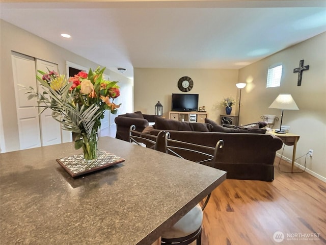 living room with recessed lighting, baseboards, and light wood-style flooring