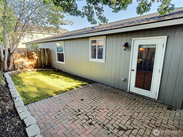 rear view of property with a lawn, a patio, and fence