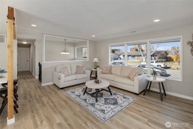 living area with recessed lighting, light wood-type flooring, baseboards, and a chandelier