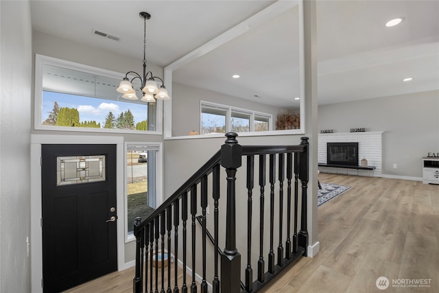 entrance foyer featuring visible vents, a notable chandelier, wood finished floors, recessed lighting, and baseboards