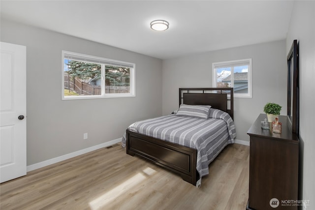 bedroom with visible vents, light wood-type flooring, and baseboards