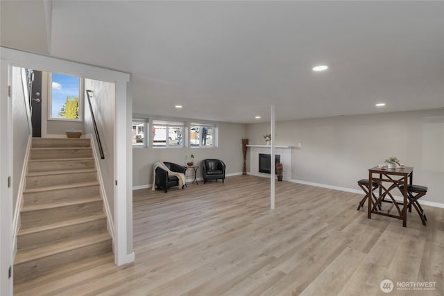 interior space with light wood-style flooring, recessed lighting, a fireplace, baseboards, and stairs