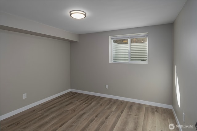 empty room with baseboards and wood finished floors