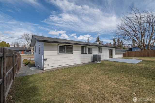 back of house with a fenced backyard, a yard, a patio, and central AC