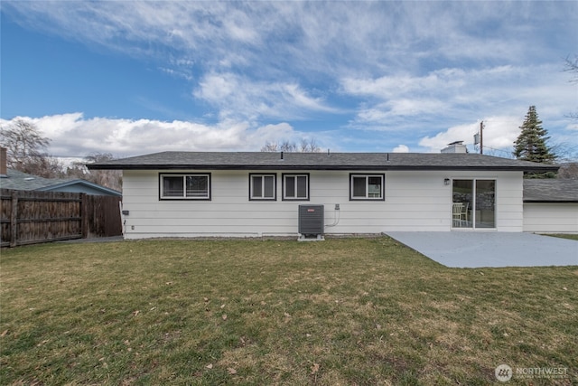 rear view of property featuring a yard, central AC unit, a patio, and fence