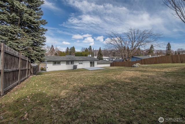 view of yard featuring central AC unit, a fenced backyard, and a patio area