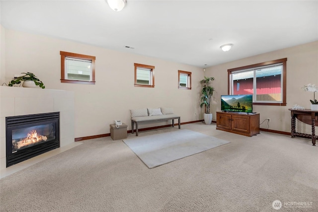 living area featuring visible vents, light carpet, baseboards, and a fireplace