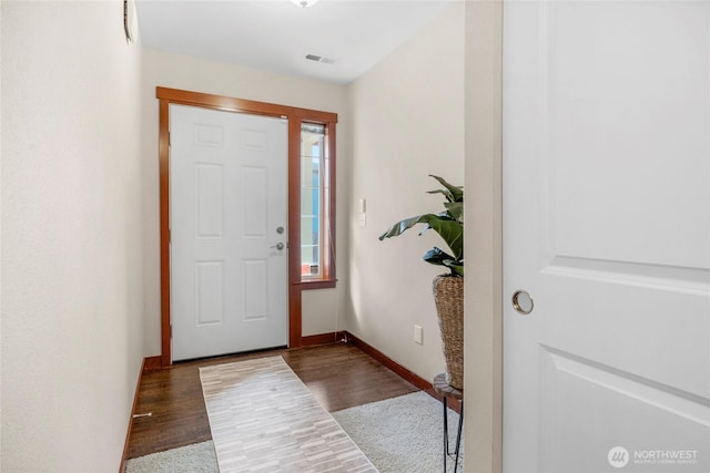 entryway featuring visible vents, baseboards, and wood finished floors