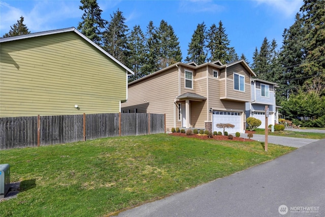 view of front of property featuring a front yard, an attached garage, driveway, and fence