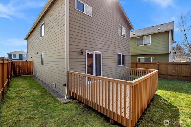 rear view of house featuring a lawn and a fenced backyard