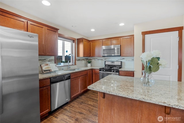 kitchen featuring a sink, stainless steel appliances, dark wood-type flooring, and backsplash