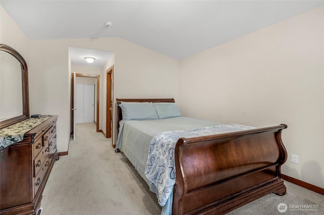 bedroom with light colored carpet, baseboards, and vaulted ceiling