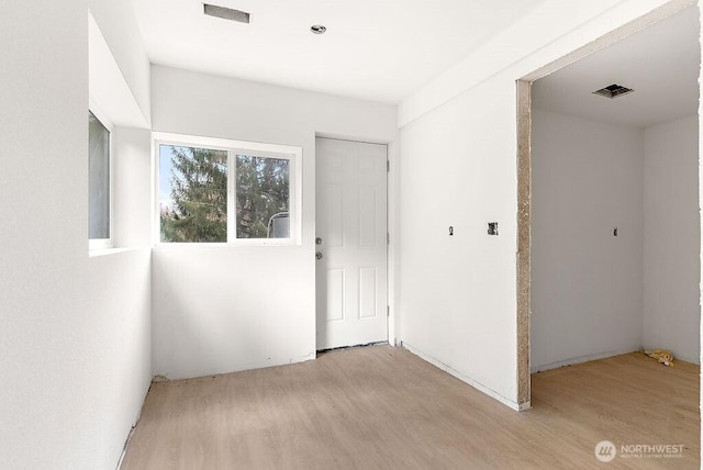 spare room with light wood-type flooring and visible vents