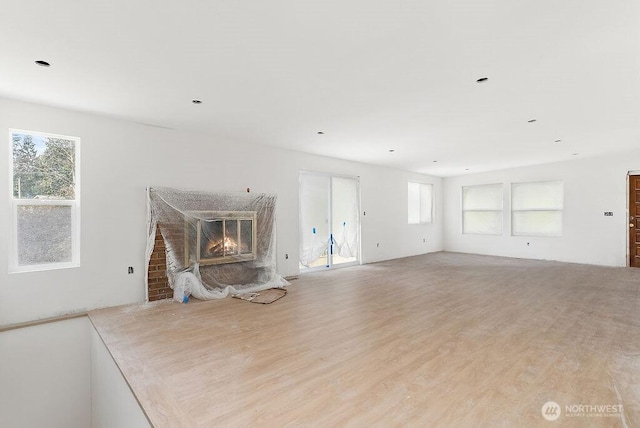 unfurnished living room featuring wood finished floors and a high end fireplace