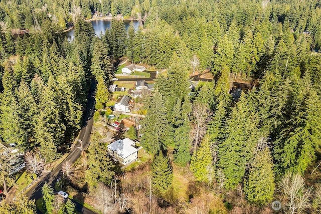 birds eye view of property featuring a view of trees and a water view