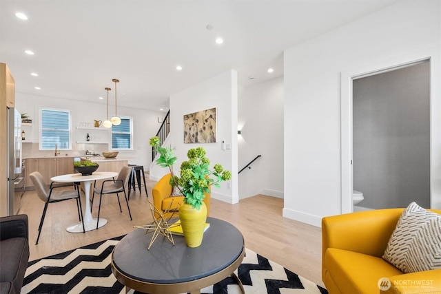 living area with light wood-style flooring, recessed lighting, and baseboards