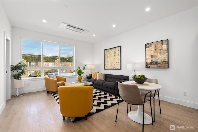 living area with recessed lighting, wood finished floors, and baseboards