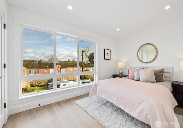 bedroom with multiple windows, wood finished floors, and recessed lighting