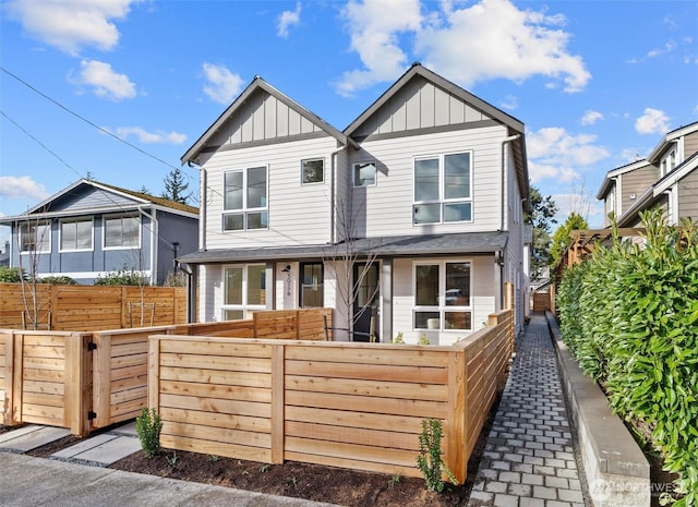 view of front of home with board and batten siding and a fenced front yard