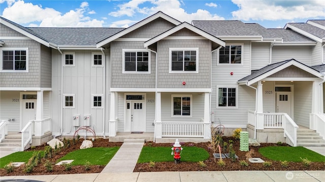 multi unit property with covered porch and a shingled roof