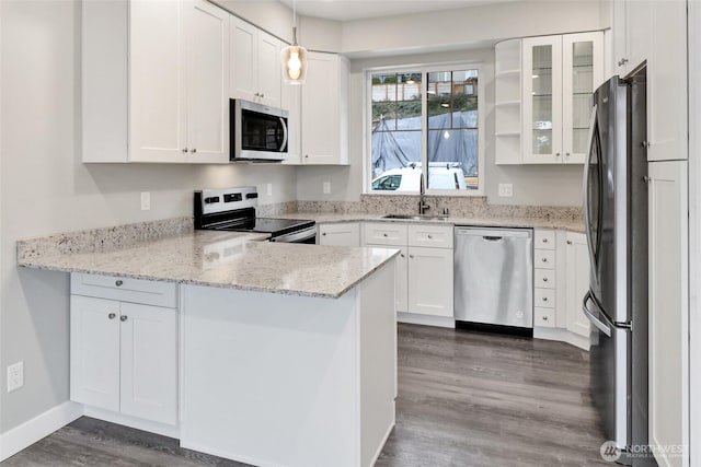 kitchen featuring white cabinetry, a peninsula, stainless steel appliances, and a sink