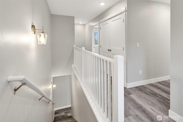 stairway featuring recessed lighting, baseboards, and wood finished floors