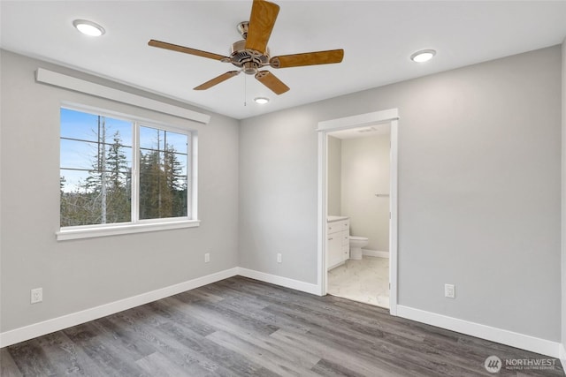 unfurnished bedroom featuring wood finished floors, baseboards, recessed lighting, ceiling fan, and connected bathroom